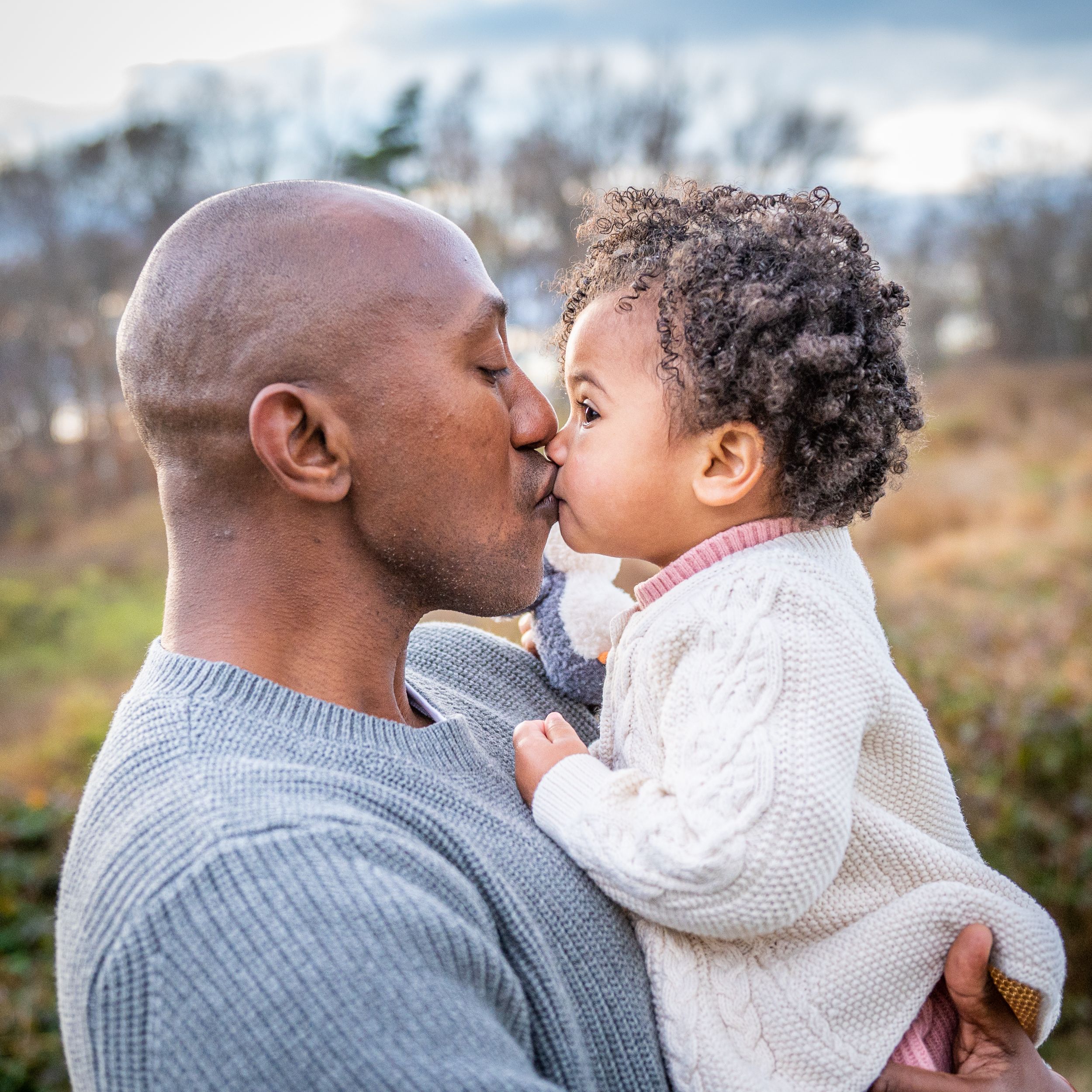 A father gives a kiss to his toddler daughter at a Washington DC family photo session.