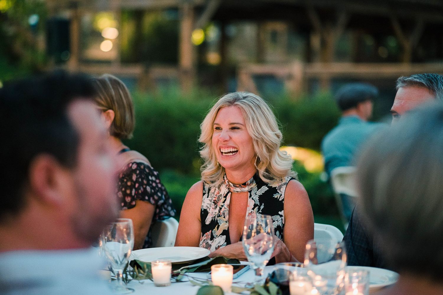 Candid evening reception scene with guests dining outdoors.