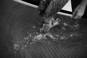 Water splashing around legs in dark moody lighting.