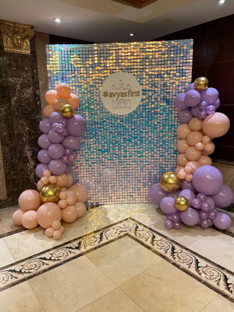 Shimmer wall birthday decor set up with pink and purple balloons