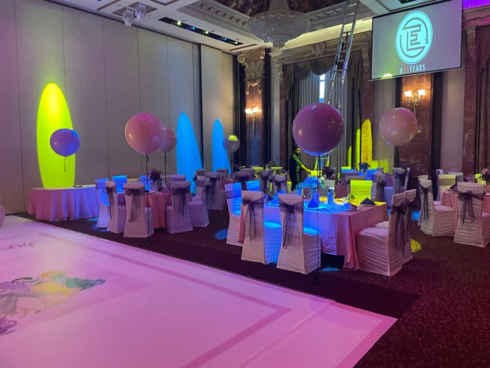 Banquet set up with floating balloons and custom floor wrap, matching theme chair sashes and guest table decor