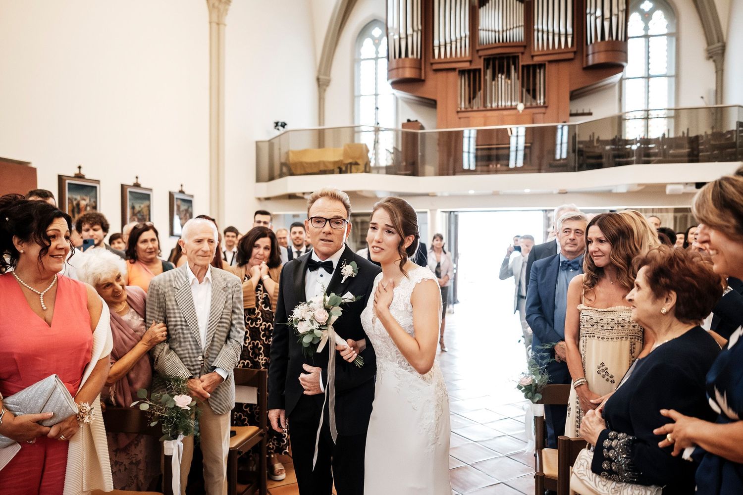 TLOOK photographe de mariage de style documentaire, église cérémonie religieuse la mariée arrive avec son papa