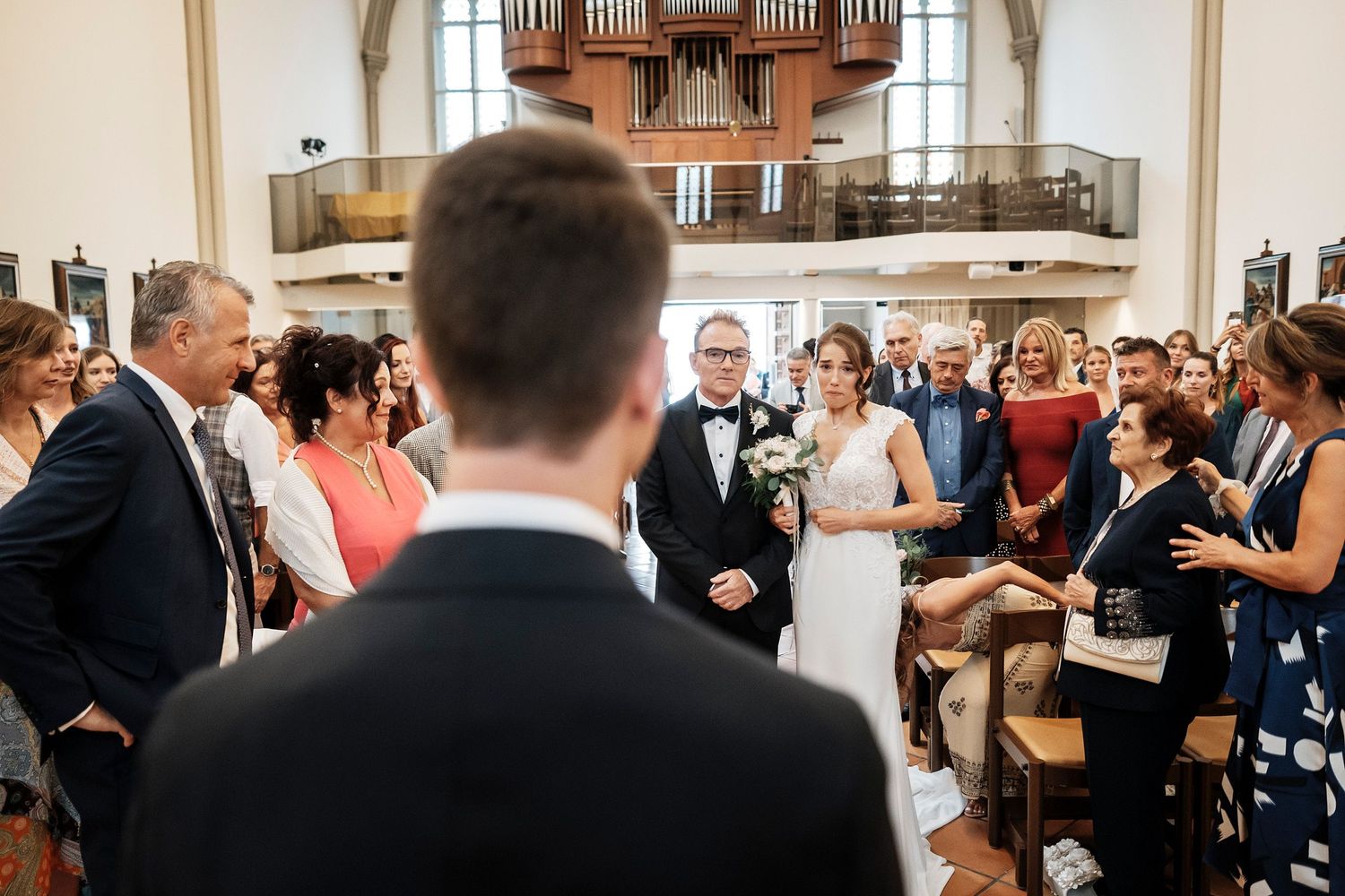 TLOOK photographe de mariage de style documentaire, église cérémonie religieuse la mariée arrive avec son papa