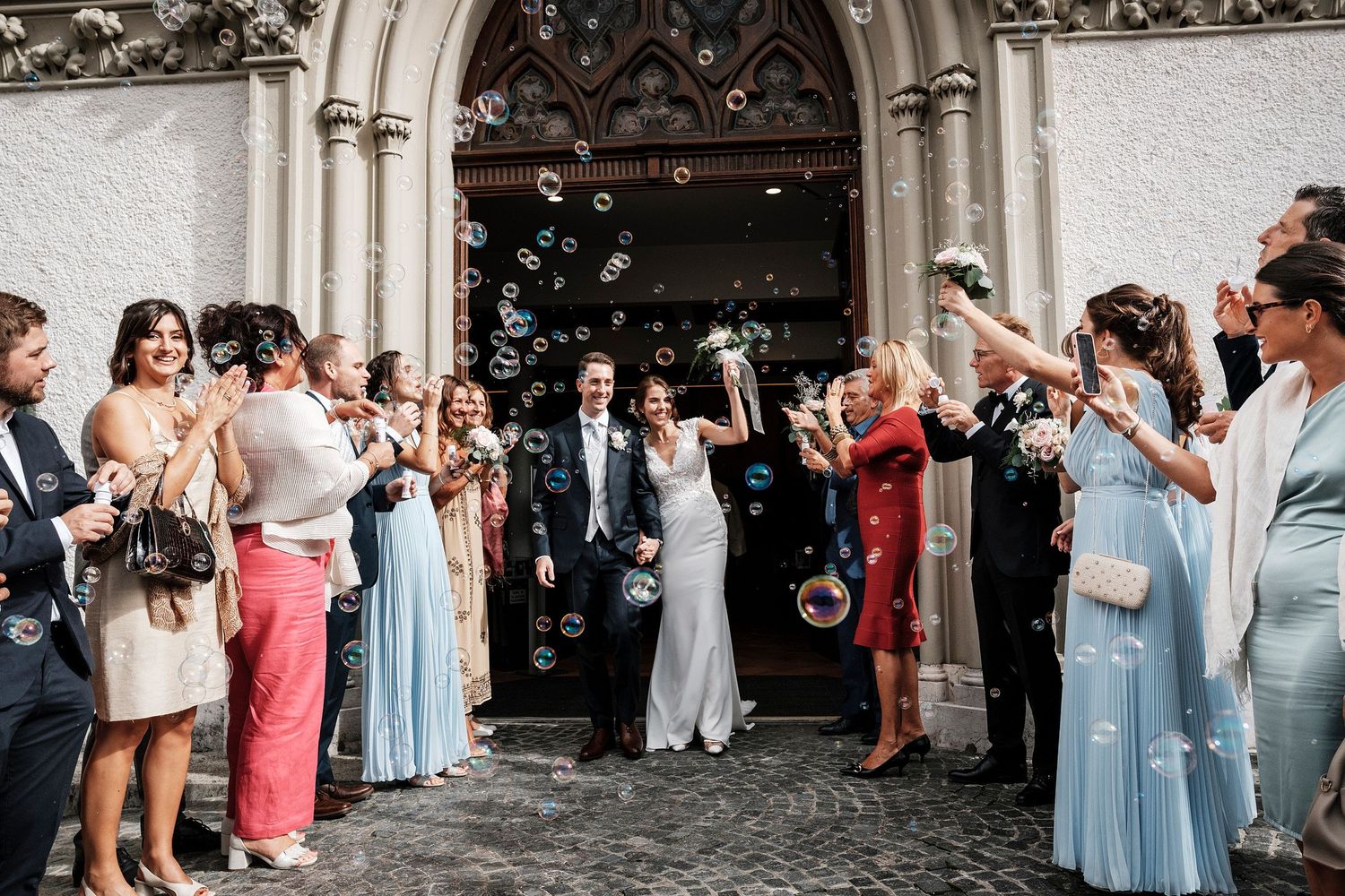 TLOOK photographe de mariage de style documentaire, sortie église émotions les marié sortent avec les bulles