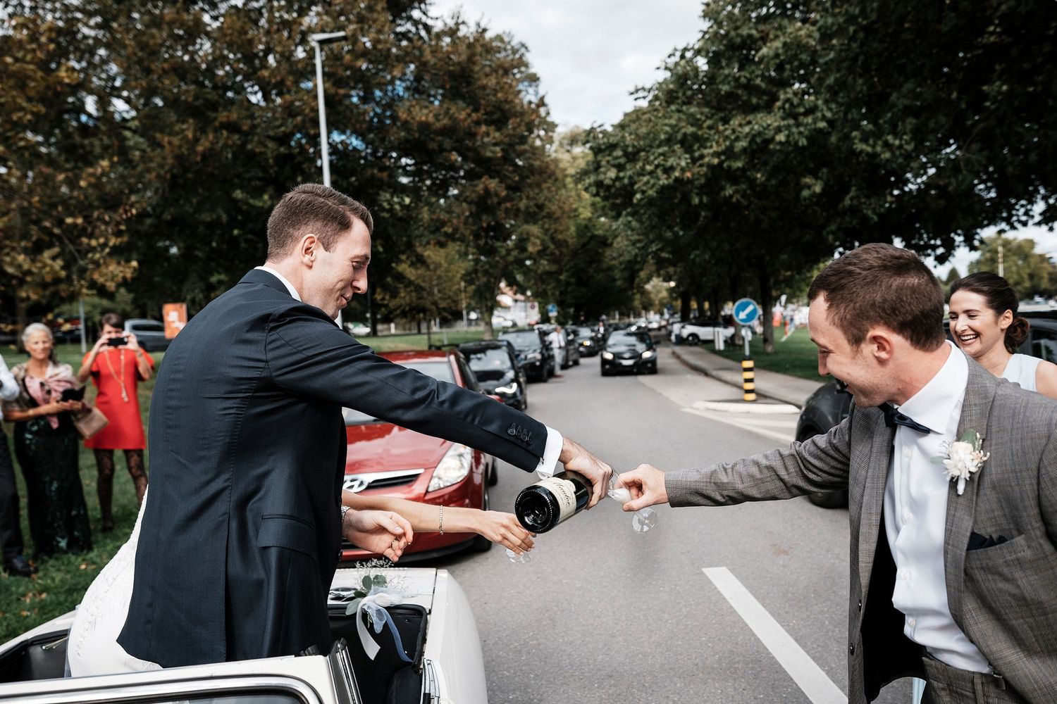 TLOOK photographe de mariage de style documentaire, domaine les Bois de Chamblard cortège voiture avec champagne
