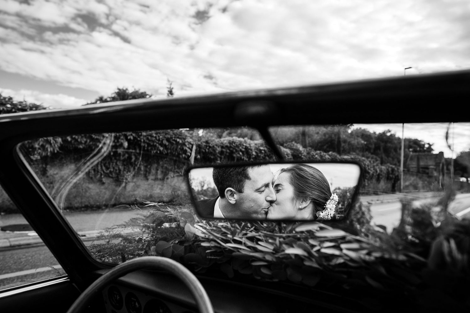 TLOOK photographe de mariage de style documentaire, domaine les Bois de Chamblard cortège voiture mariés s'embrassent dans le rétroviseur