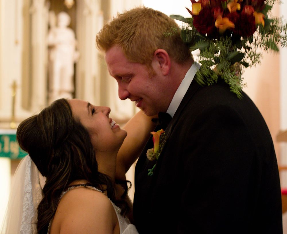 Intimate moment between newlyweds during church ceremony.