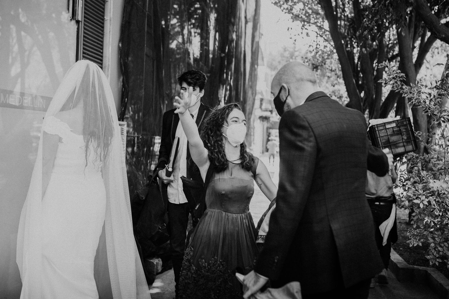 Wedding party gathered outdoors in black and white candid celebration shot.