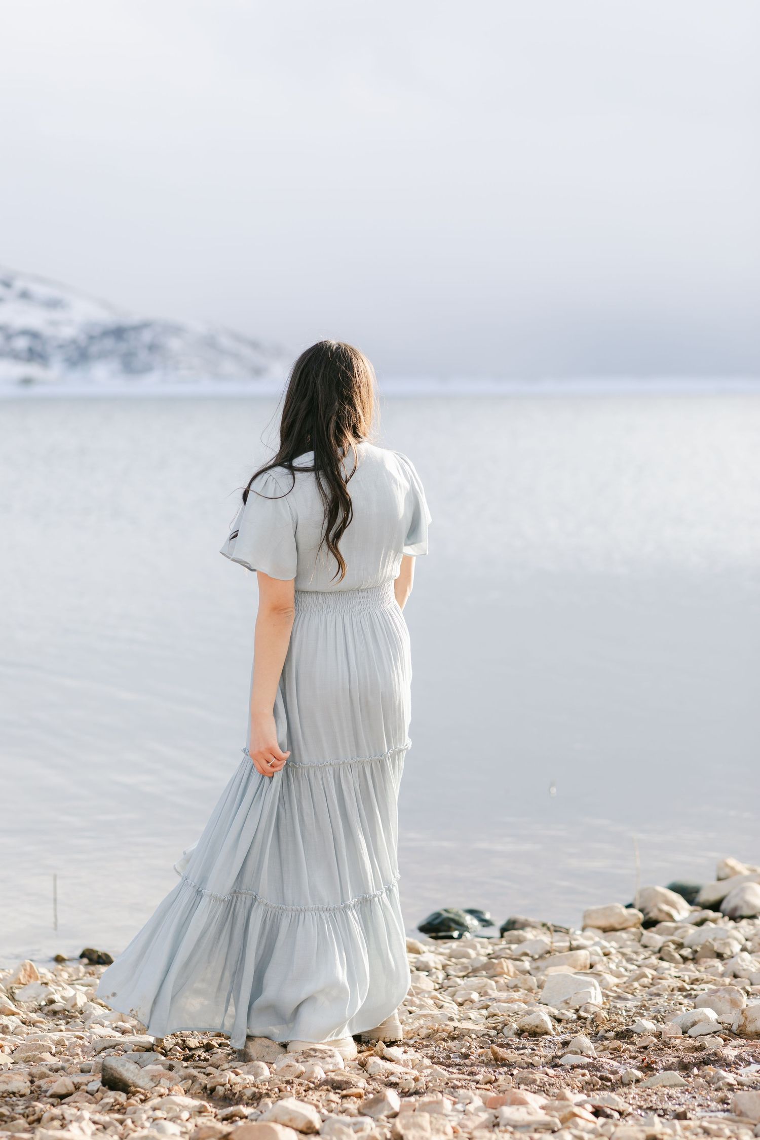 Looking into the water beautiful blue dress. Cascading hair down the back