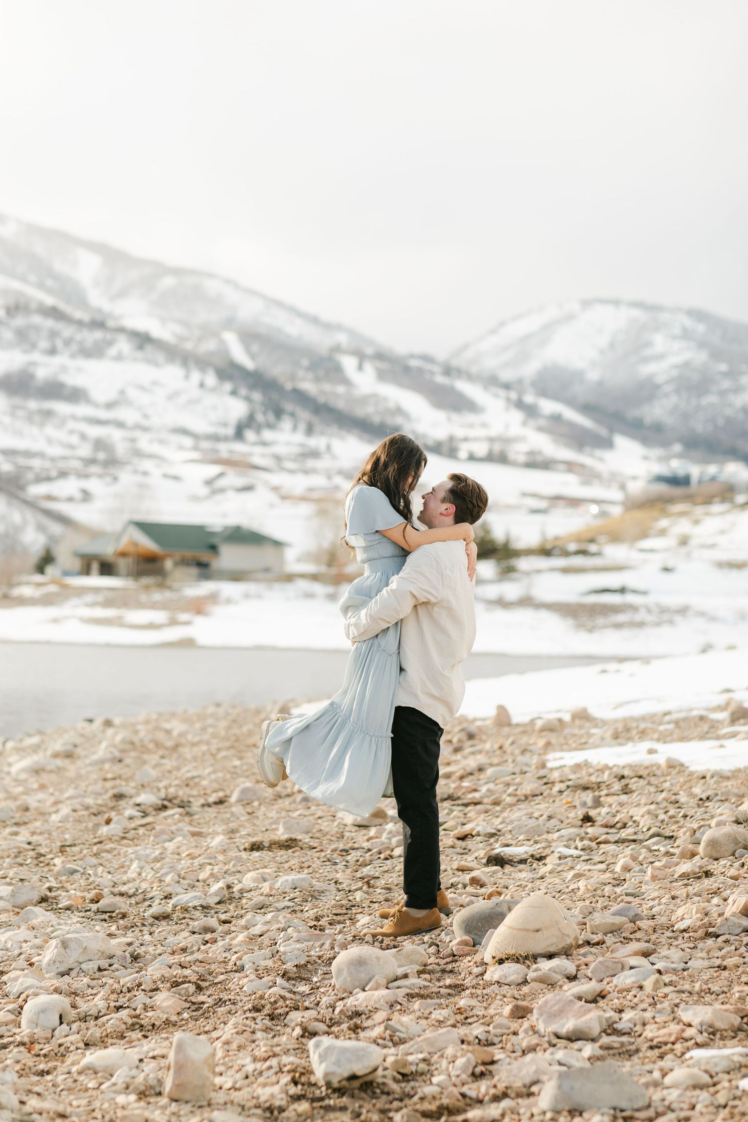 The lift and pop pose. Snowy Mountains and rocky beach jump and kiss engagement session in Jordanelle Utah
captured by Chelsee Rawe Photogra