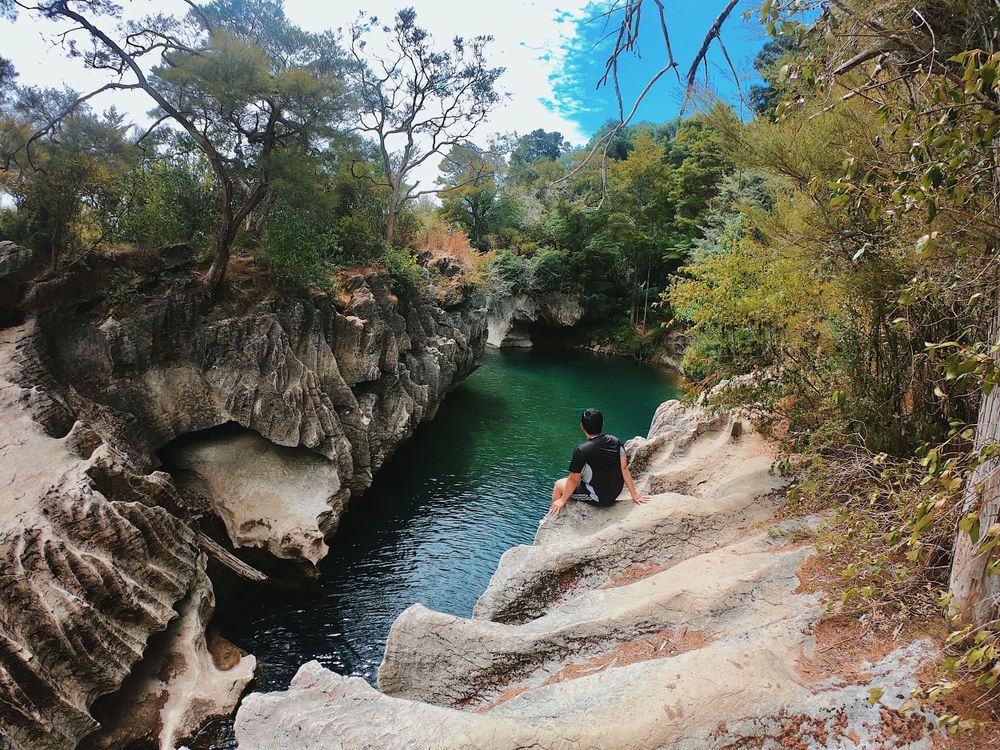 Crystal clear turquoise water flows through rocky canyon walls with steep cliffs.