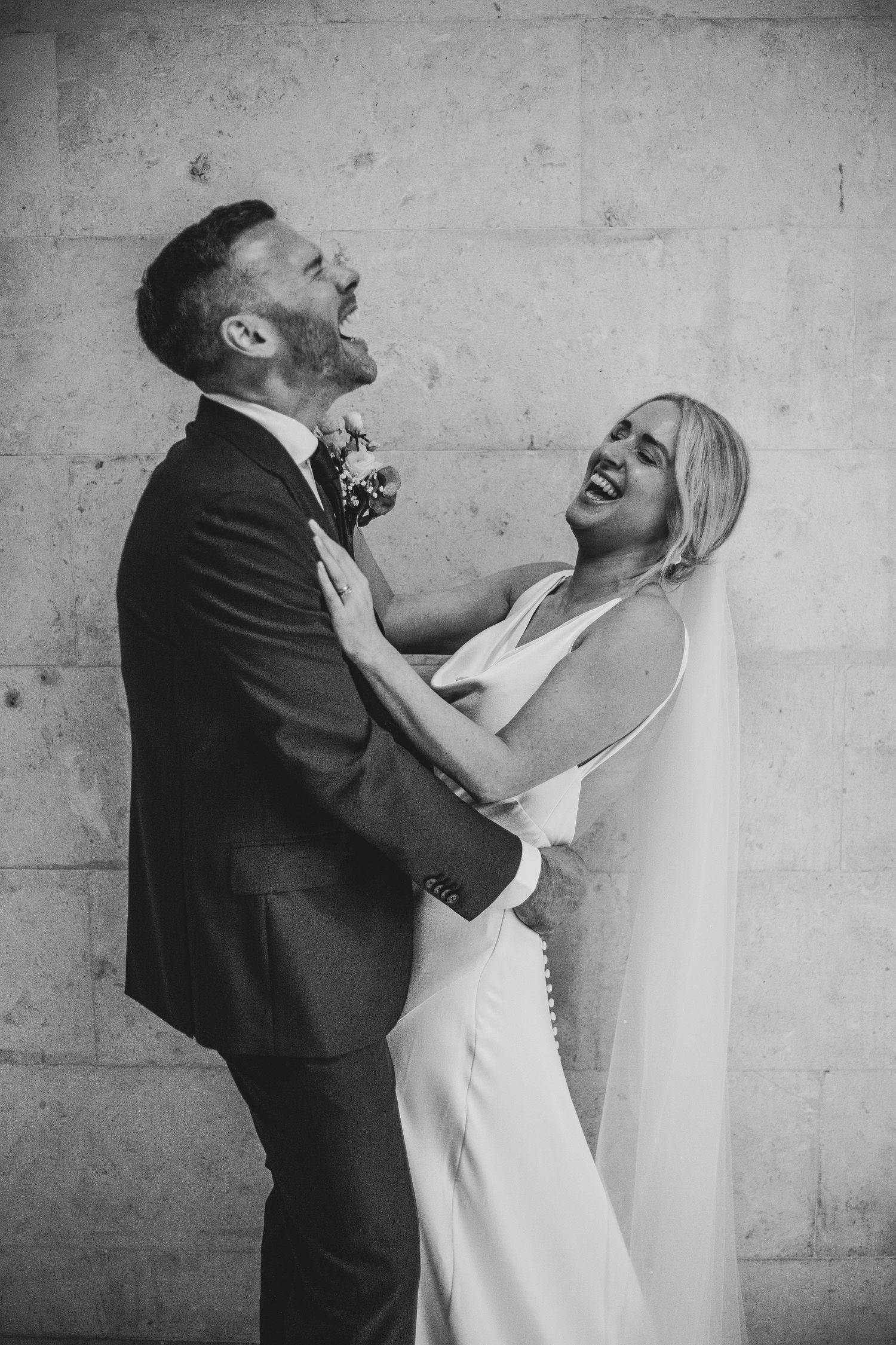 bride and groom laughing and embracing at Old Marylebone Town Hall, London by Dominique Lauren photography