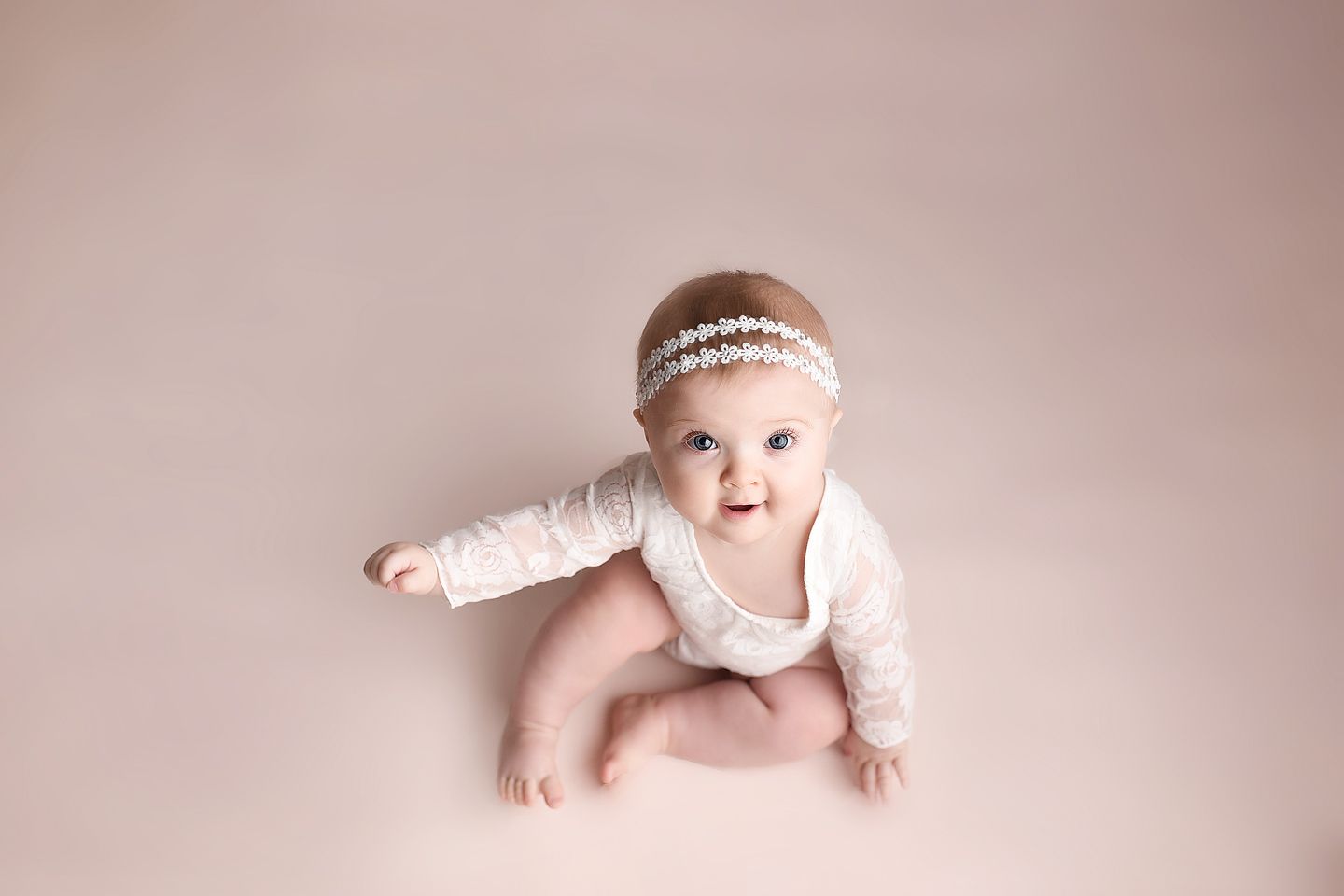 Sitting up baby girl on pink backdrop