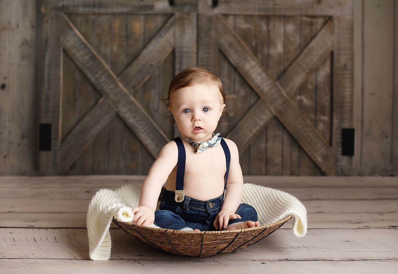 Baby posed in a basket with a bowtie
