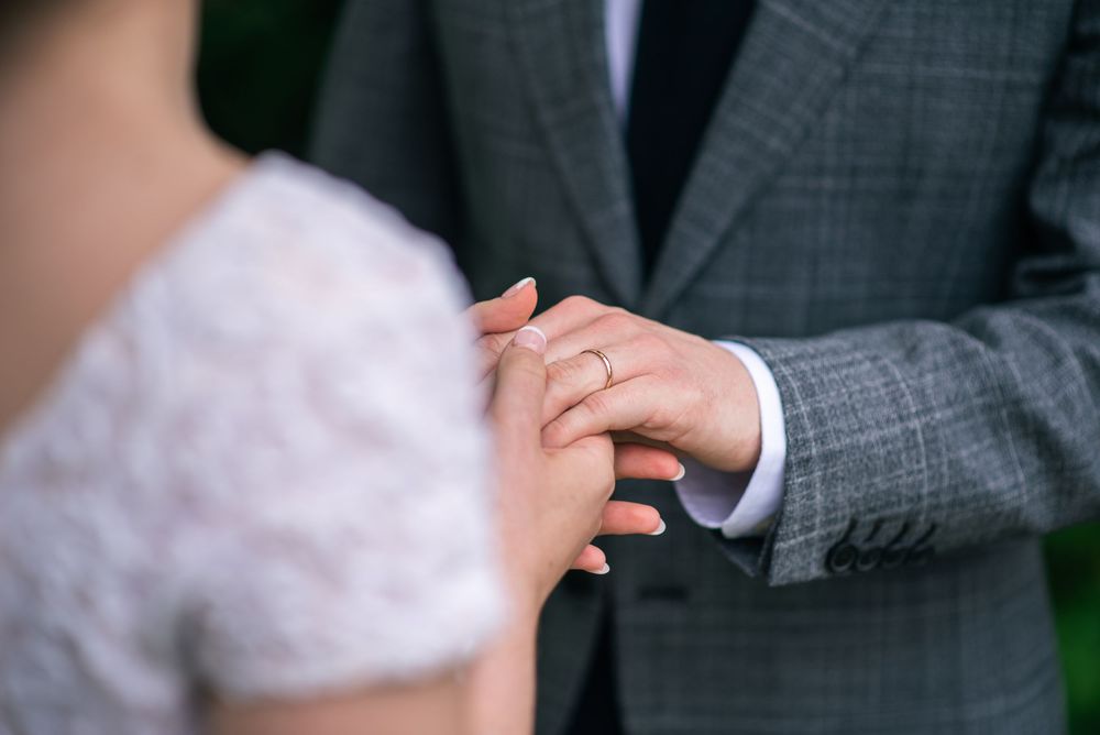Bride and groom holding hands detail