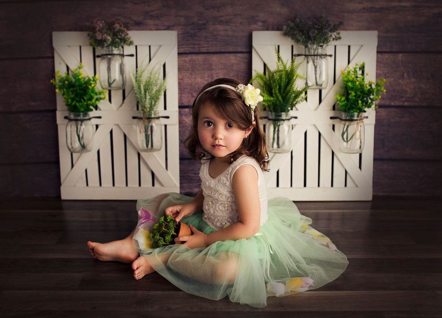toddler in a tulle dress surrounded by plants photography studio