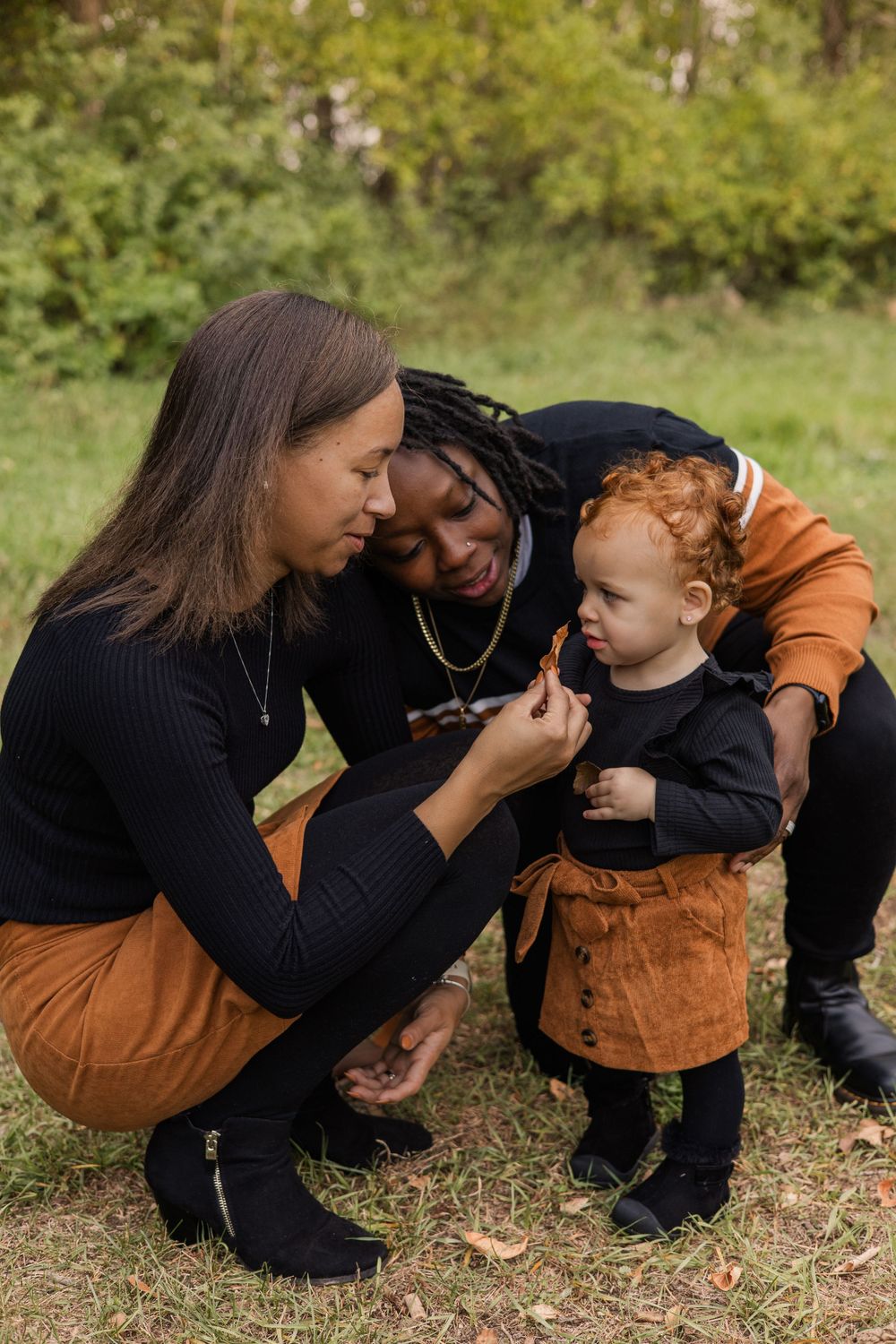 A tender family moment outdoors with a small child in autumn attire.