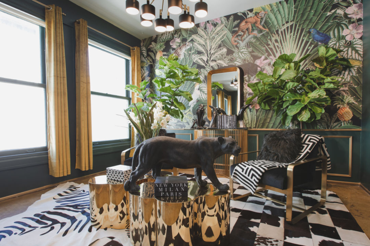 Eclectic living room with zebra rug, tropical wallpaper, and decorative black panther statue.