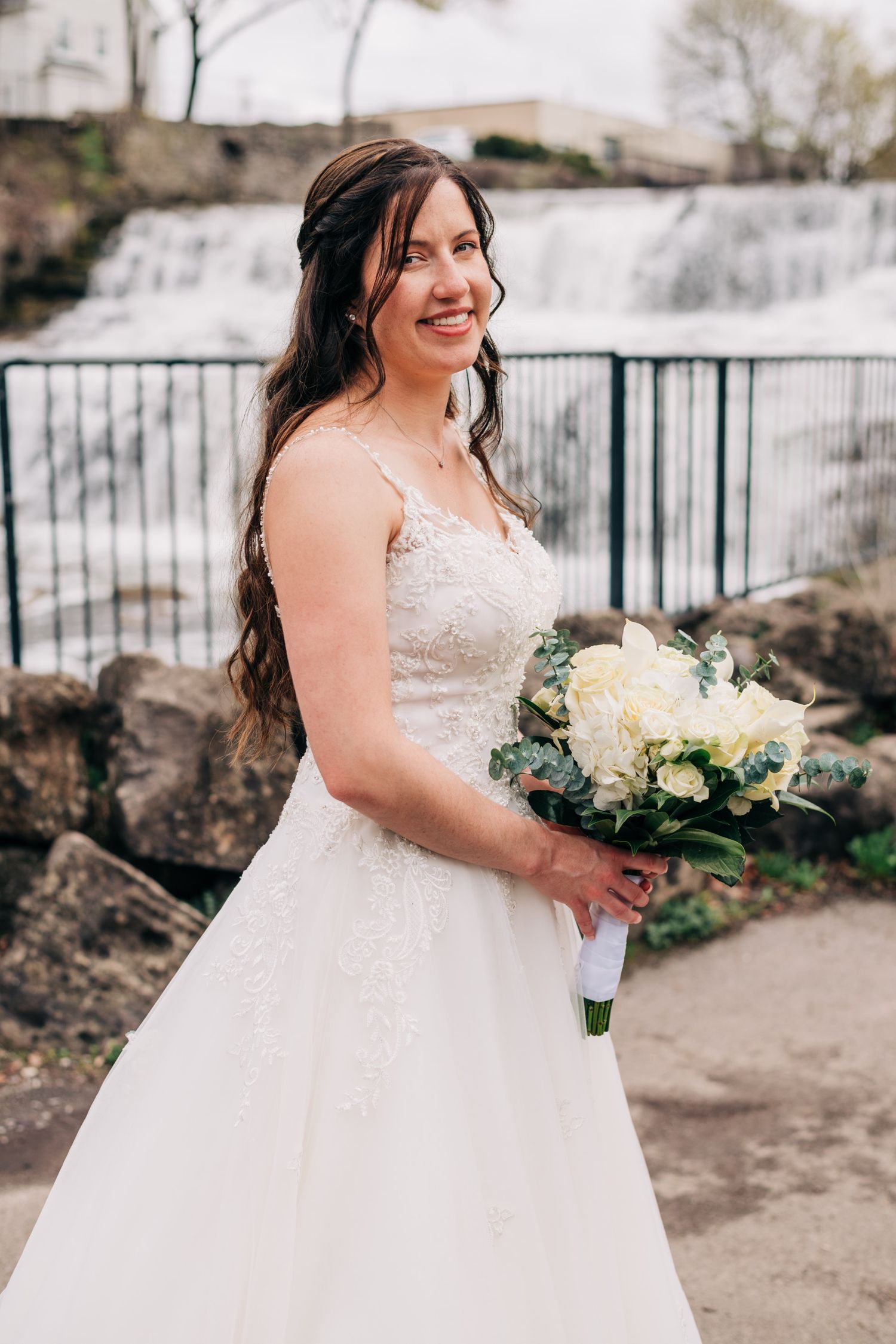 portrait photo of bride in front of a waterfall
