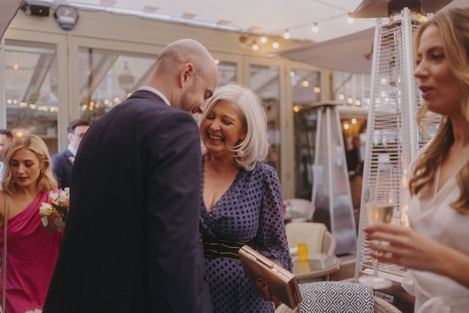 Guests share a warm moment during an elegant indoor wedding reception.