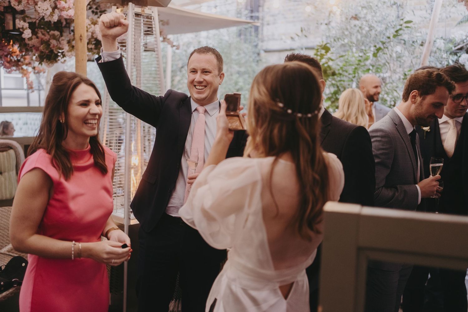 Celebratory moment at a wedding reception with guests dancing and enjoying themselves.