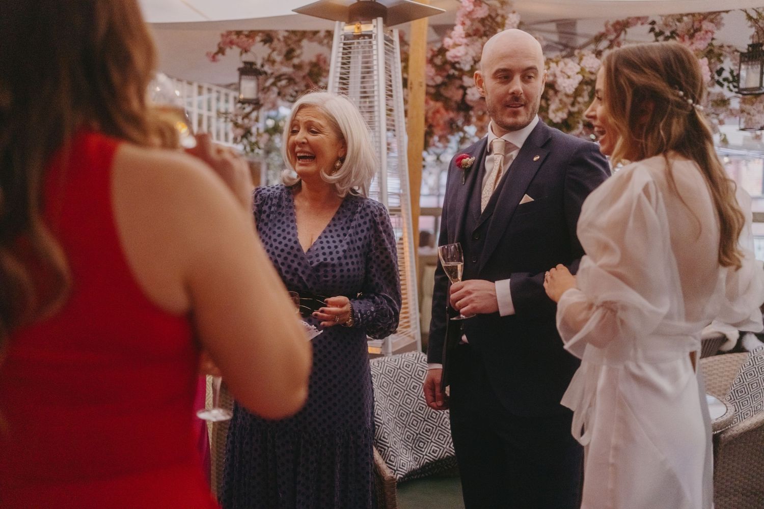 Guests share stories and laughs during an elegant indoor wedding reception.