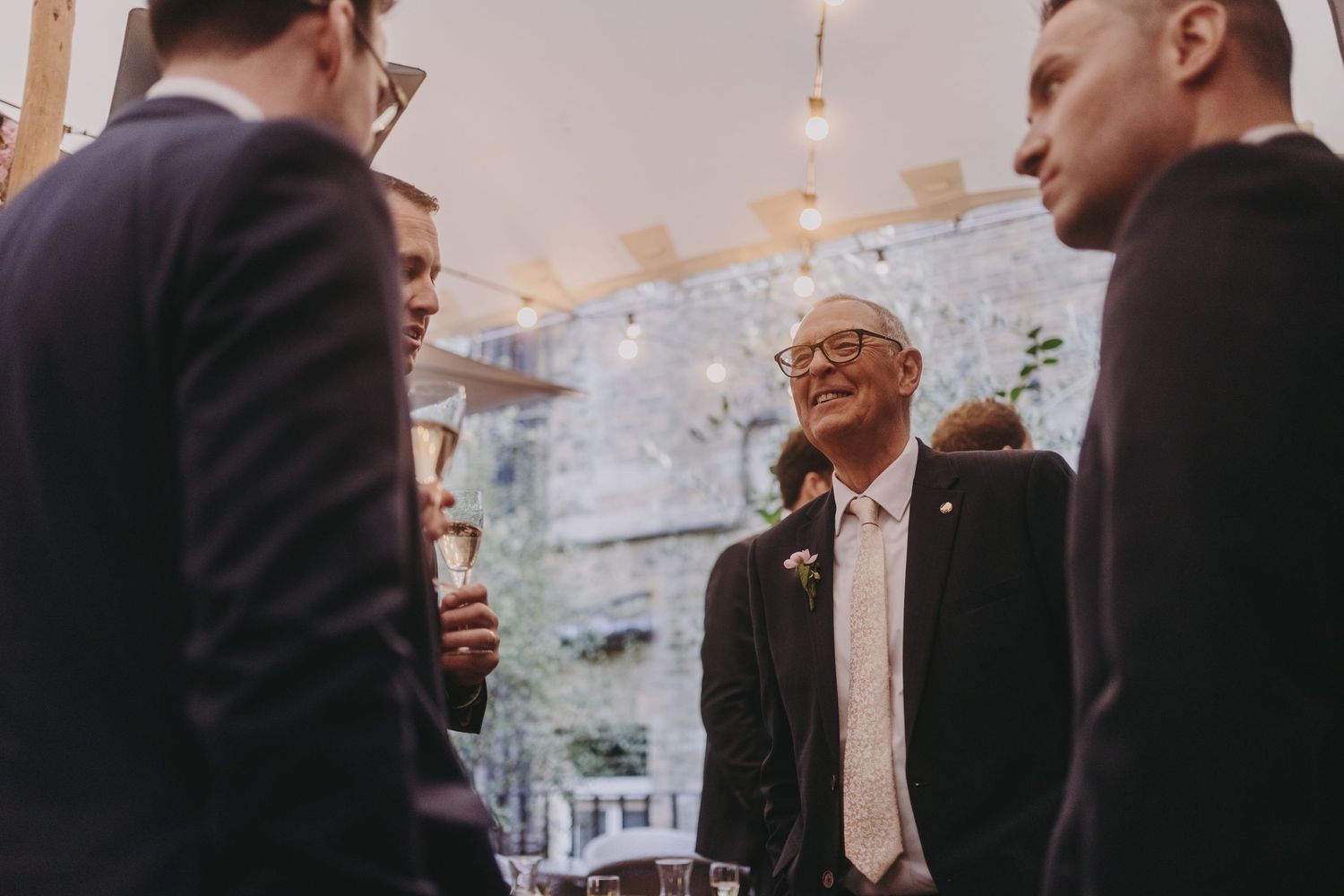 A small group engaged in conversation at an evening social event.