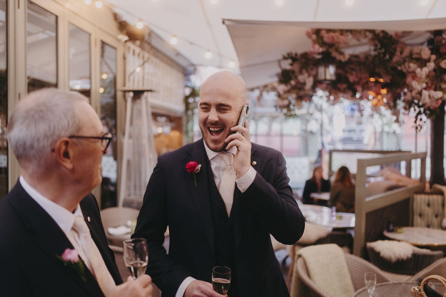 Two guests in formal attire having a conversation at an elegant wedding reception.