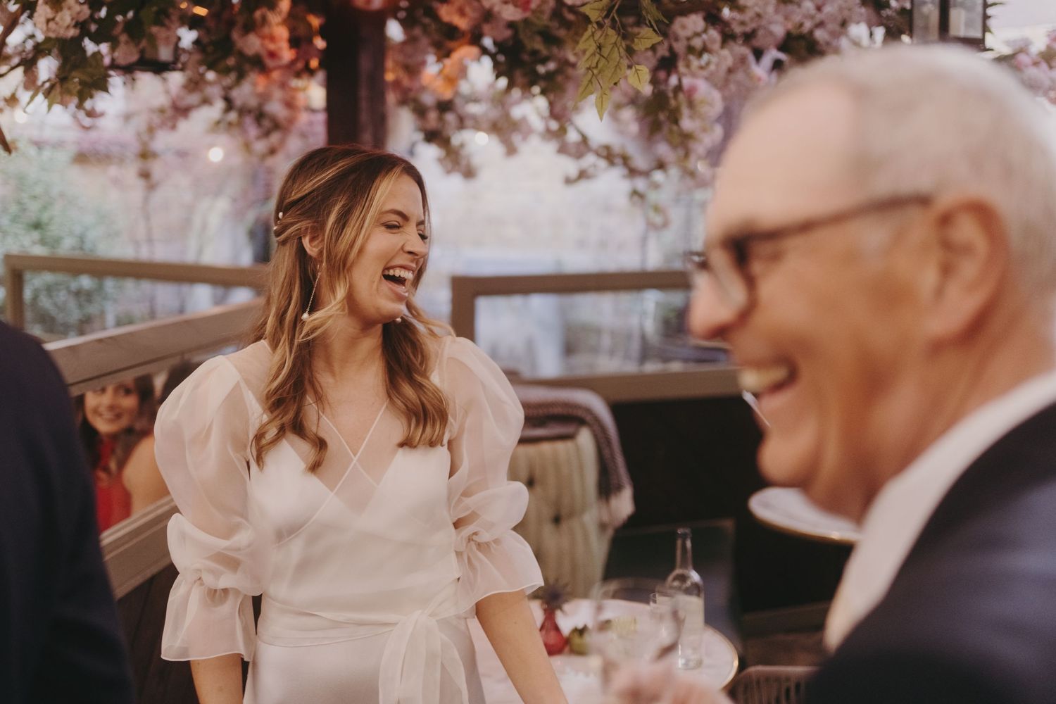 Candid moment of joy shared between wedding guests during elegant reception.