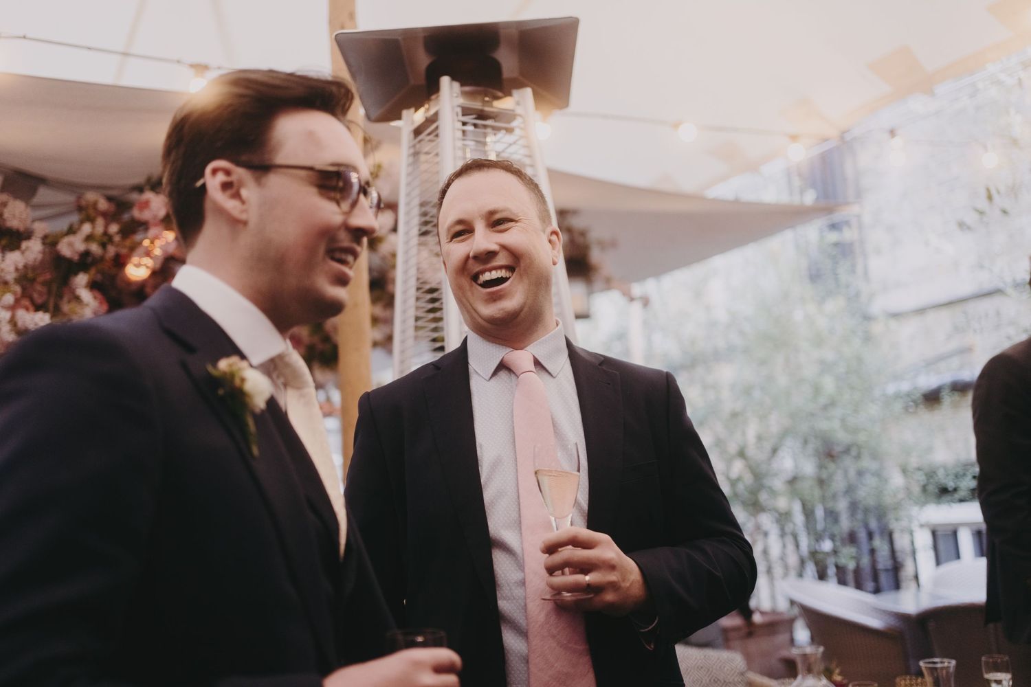 Two guests sharing a laugh during an outdoor social gathering.