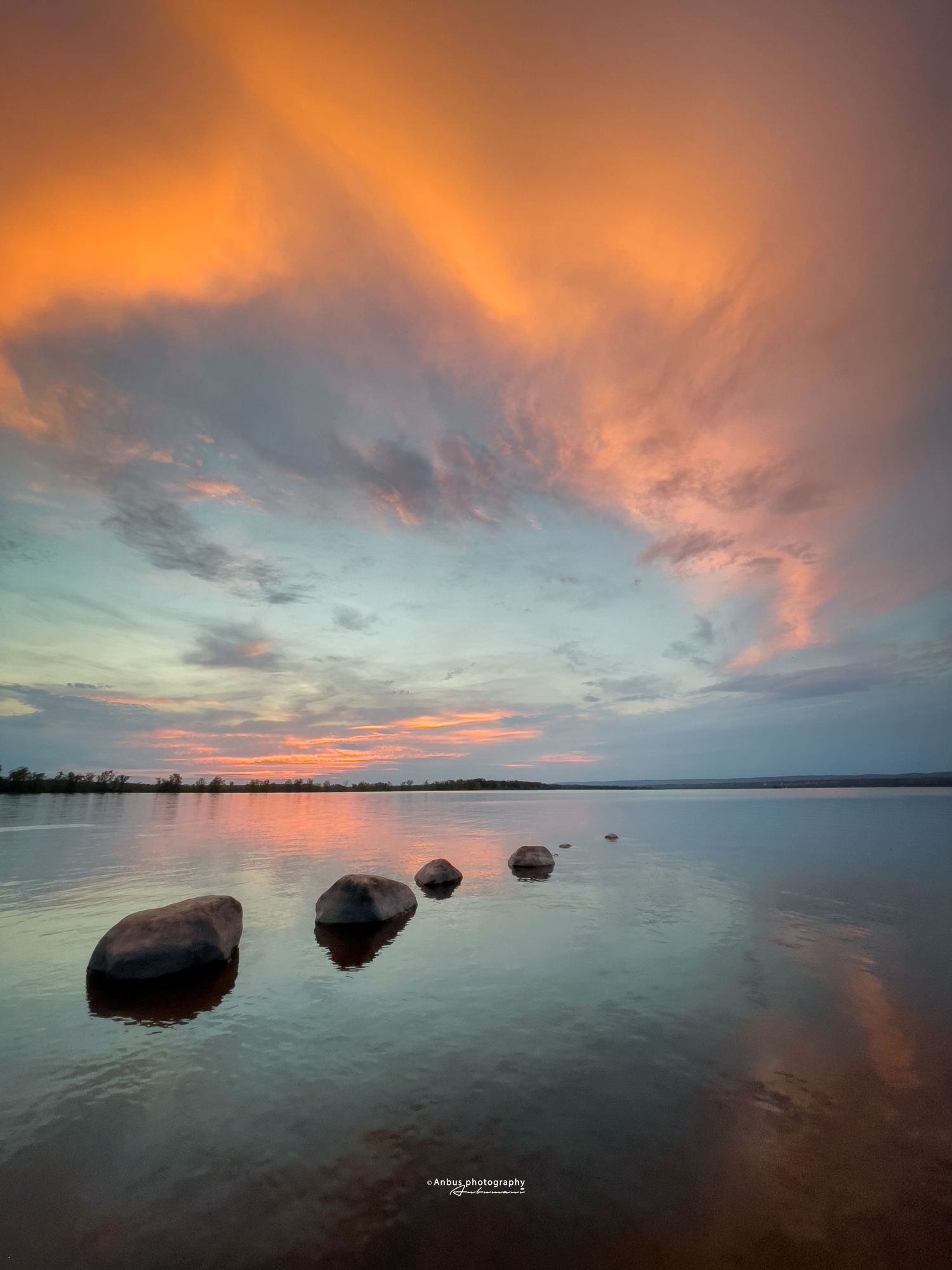 colourful golden hour in a river with rocks in the foreground