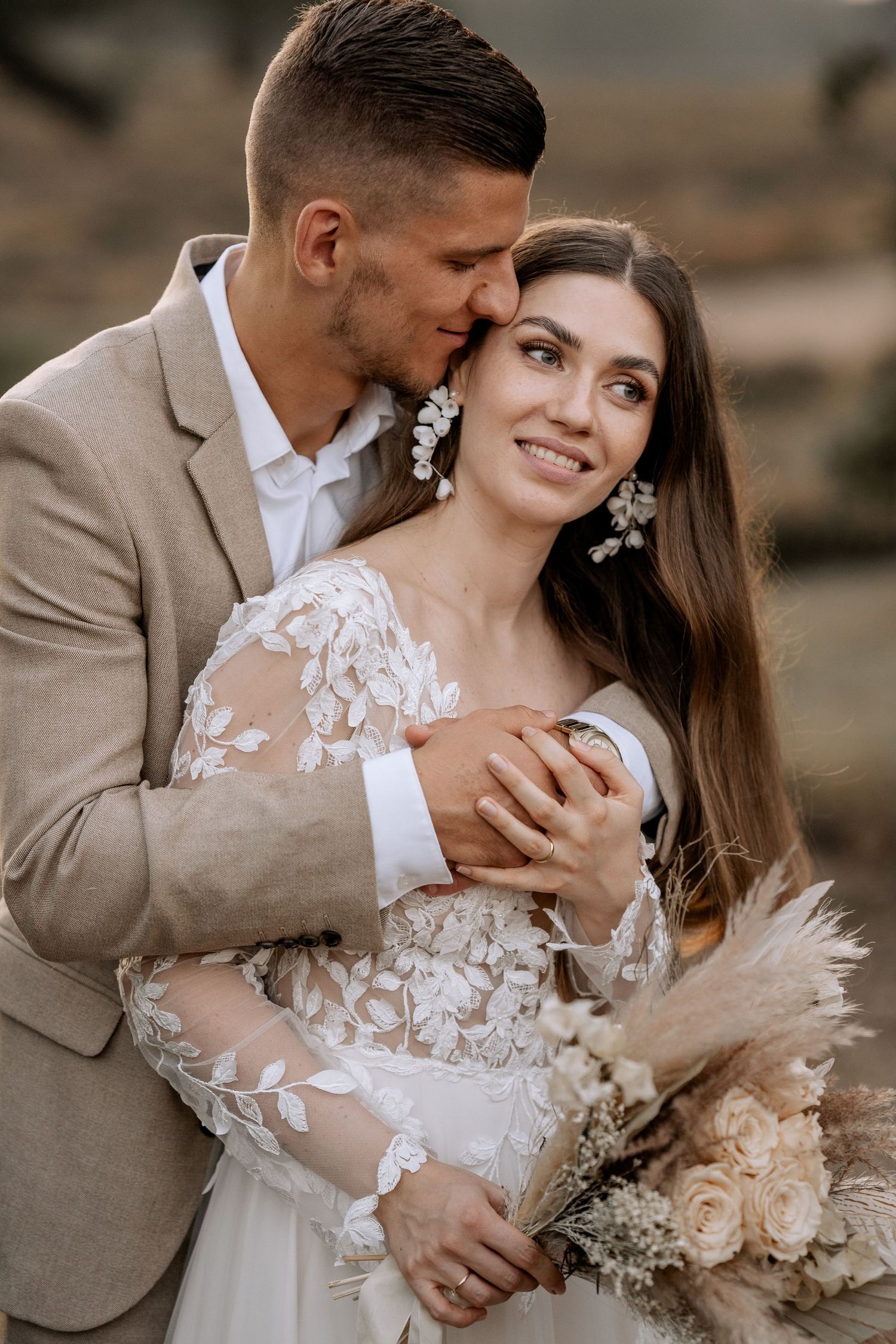 Intimate wedding portrait with elegant lace dress and neutral toned suit.