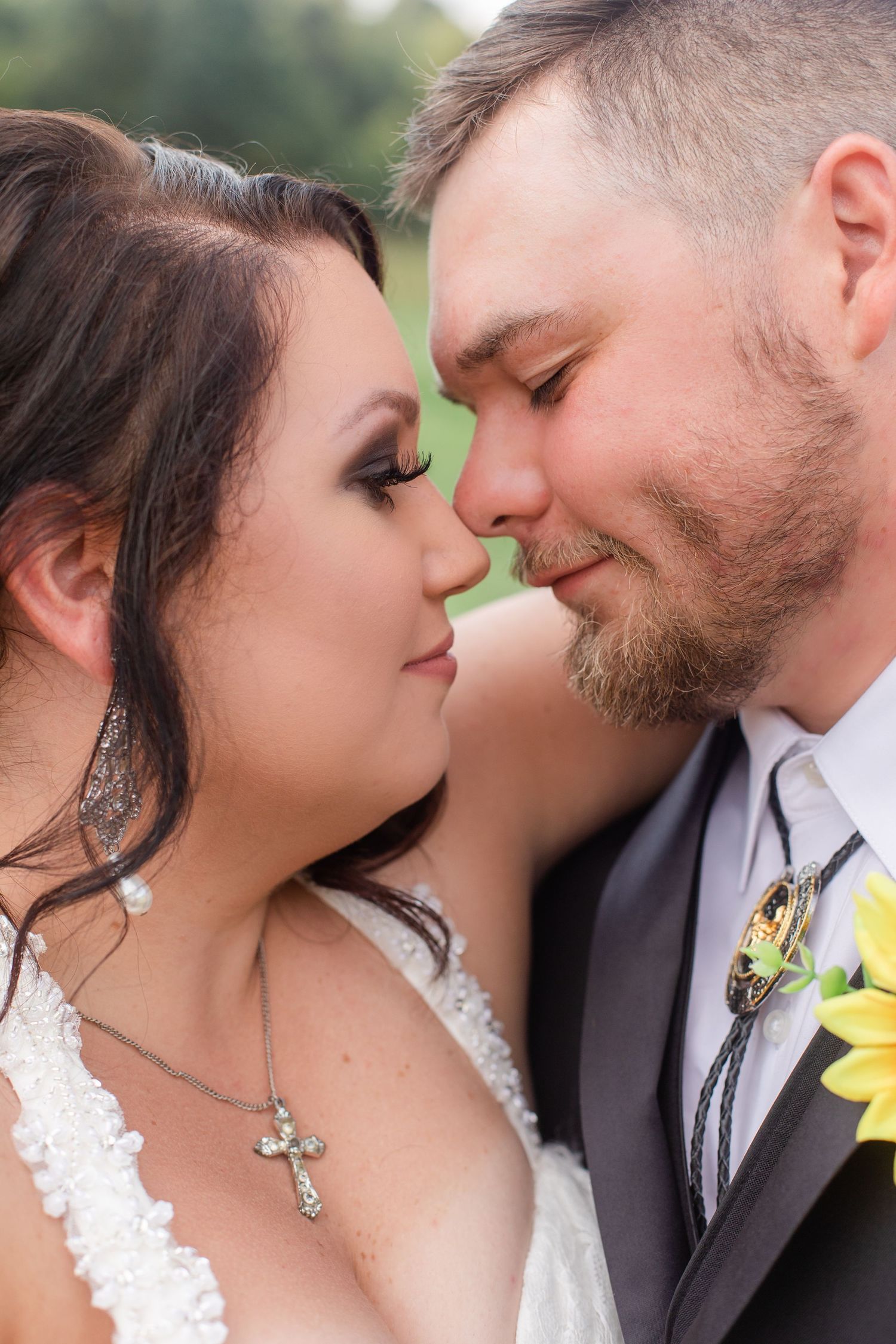 Intimate close-up wedding portrait with sunflower boutonniere detail.