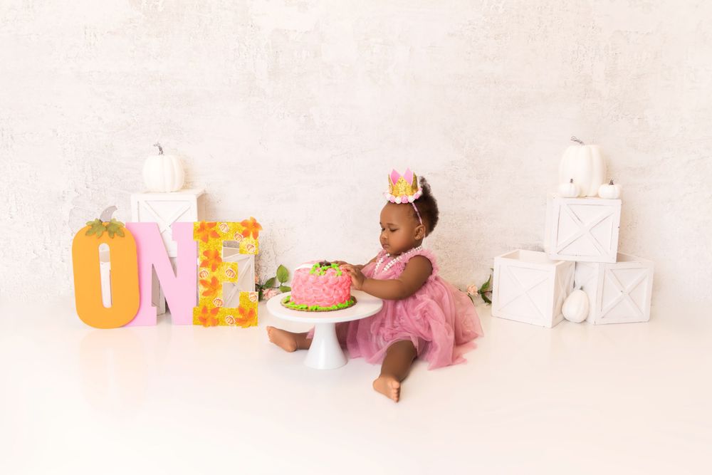 First birthday cake smash setup with pink tutu and decorative number one.