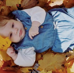 baby girl lays in leaves