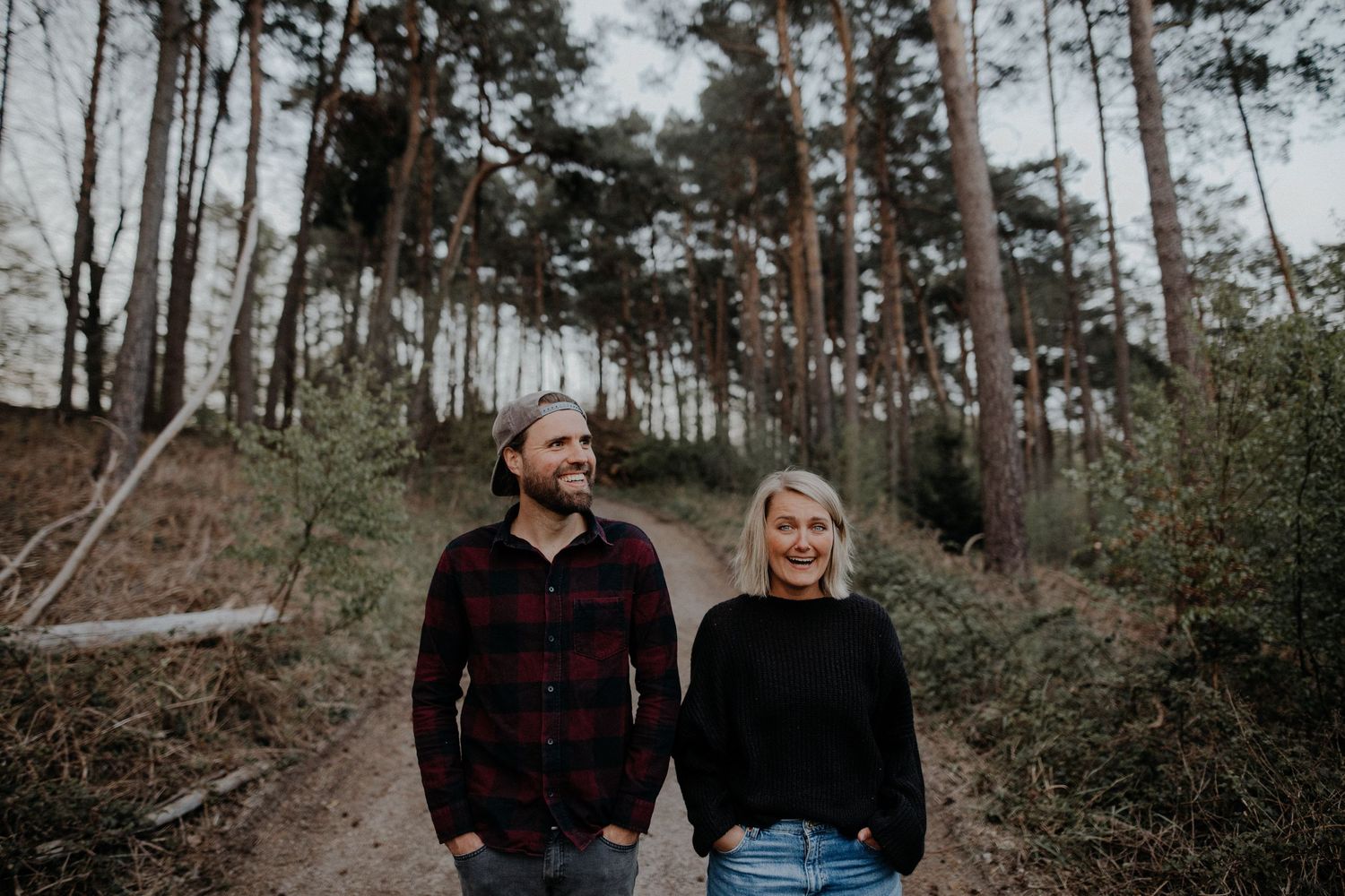 A romantic couple portrait series captured in a forest setting with soft natural lighting.