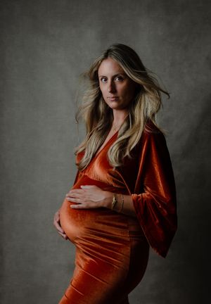 Zwangerschap foto studio -  vrouw in lange oranje jurk