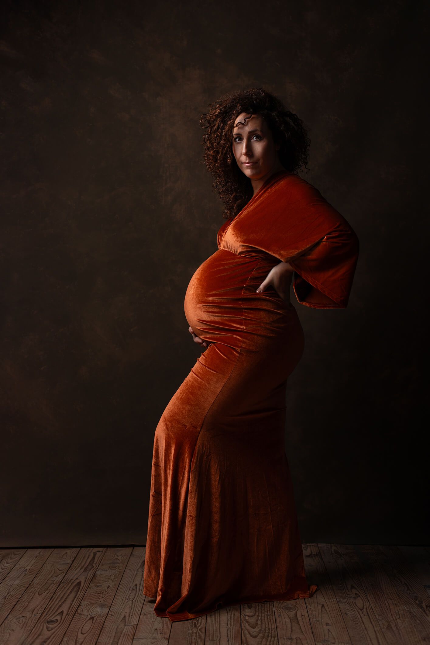Zwangere voor backdrop -  vrouw in lange oranje jurk