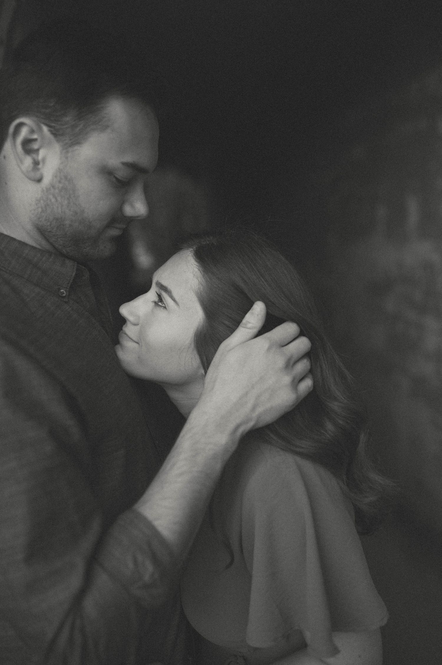 Black and white intimate portrait of a couple sharing a gentle moment.