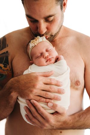A series of intimate black and white photos showing tender moments between a parent and newborn baby.