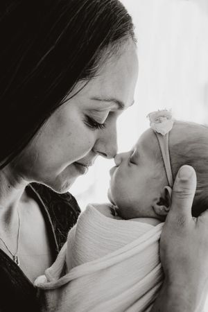 Black and white photo sequence capturing intimate bonding moments with a newborn.