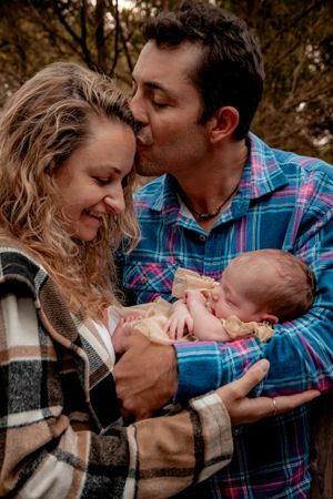 Tender family moment outdoors with plaid and flannel clothing.
