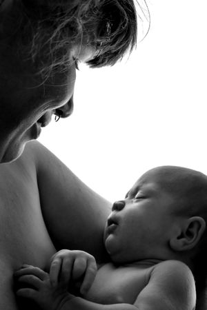 Intimate black and white silhouette of nursing mother and baby.