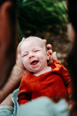 Progressive shots of baby in red clothing showing joyful expressions.