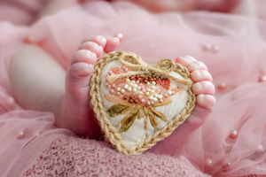 Delicate pink fabric with ornate gold decorative details.