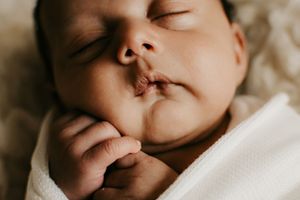 Peaceful sleeping newborn close-up in soft natural lighting.