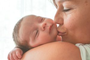 Tender newborn photography session with soft white background.