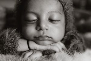 Close-up black and white portrait of a peaceful sleeping baby with soft lighting.