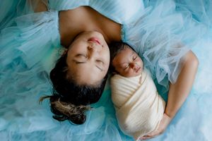 Dreamy portrait of sleeping figures on light blue tulle fabric background.