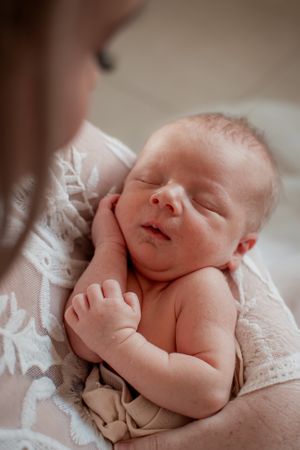 Peaceful sleeping newborn baby wrapped in delicate lace.
